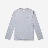 Teddy LS Tee Grey Melange - Tonsure. Oplev den perfekte kombination af stil og komfort med Tonsure's langærmede t-shirt. Fremstillet af blød bomuld og bæredygtige materialer, giver denne t-shirt optimal komfort hele dagen. Med et minimalistisk skandinavisk design og en regular fit, er den ideel til både hverdagsbrug og afslappede anledninger.